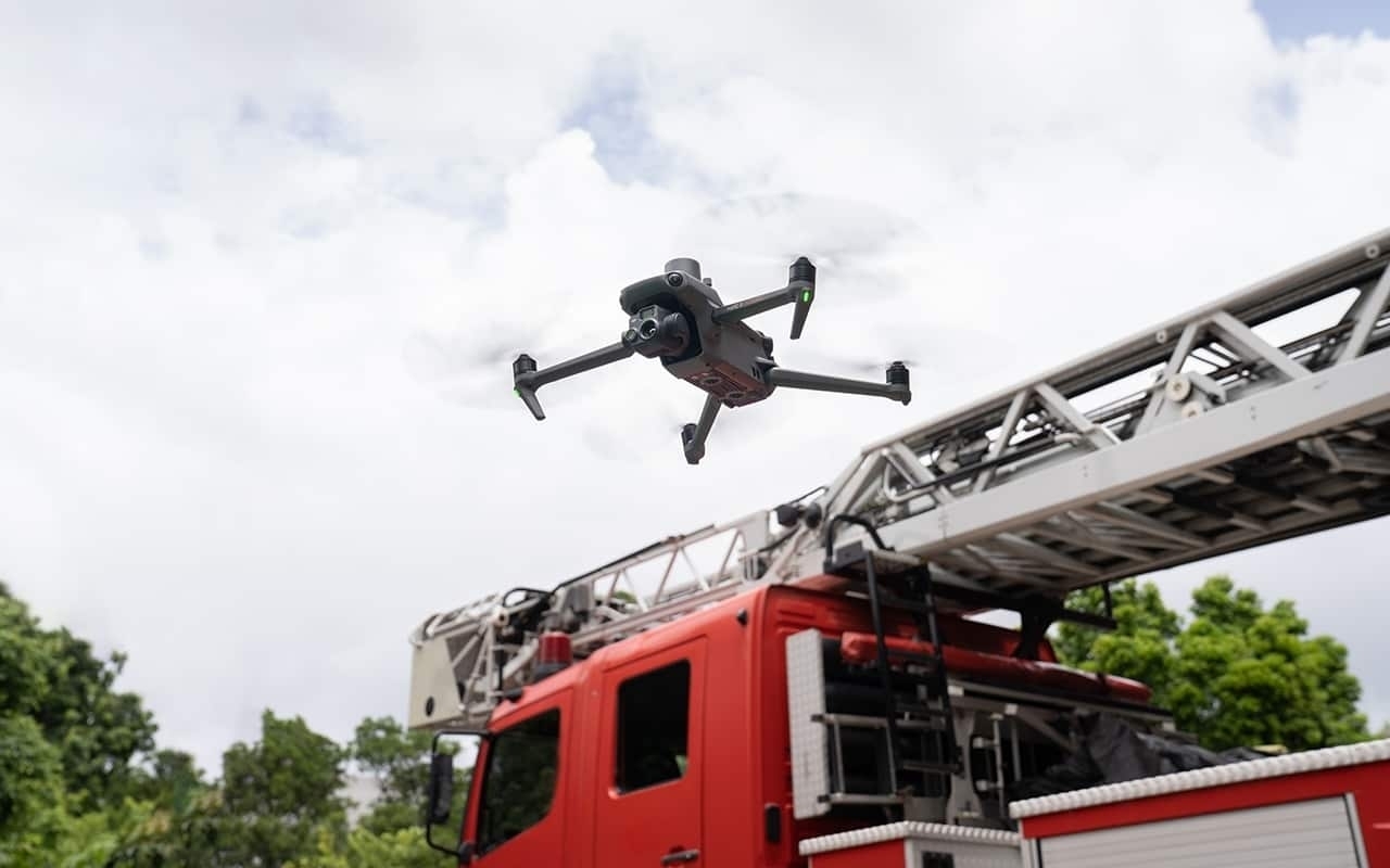 DJI Mavic 3 Thermal C2 fliegt über einem Feuerwehrauto mit Leiter in der Luft.