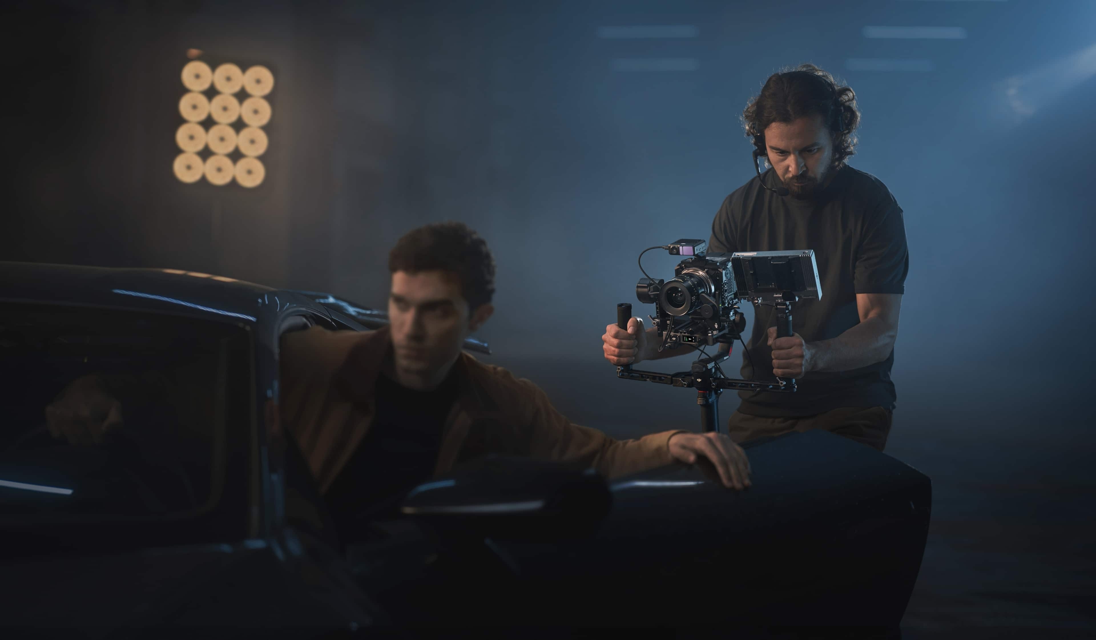 Filmemacher mit DJI RS 4 Pro Combo Gimbal im Einsatz, während ein Schauspieler im Auto sitzt.