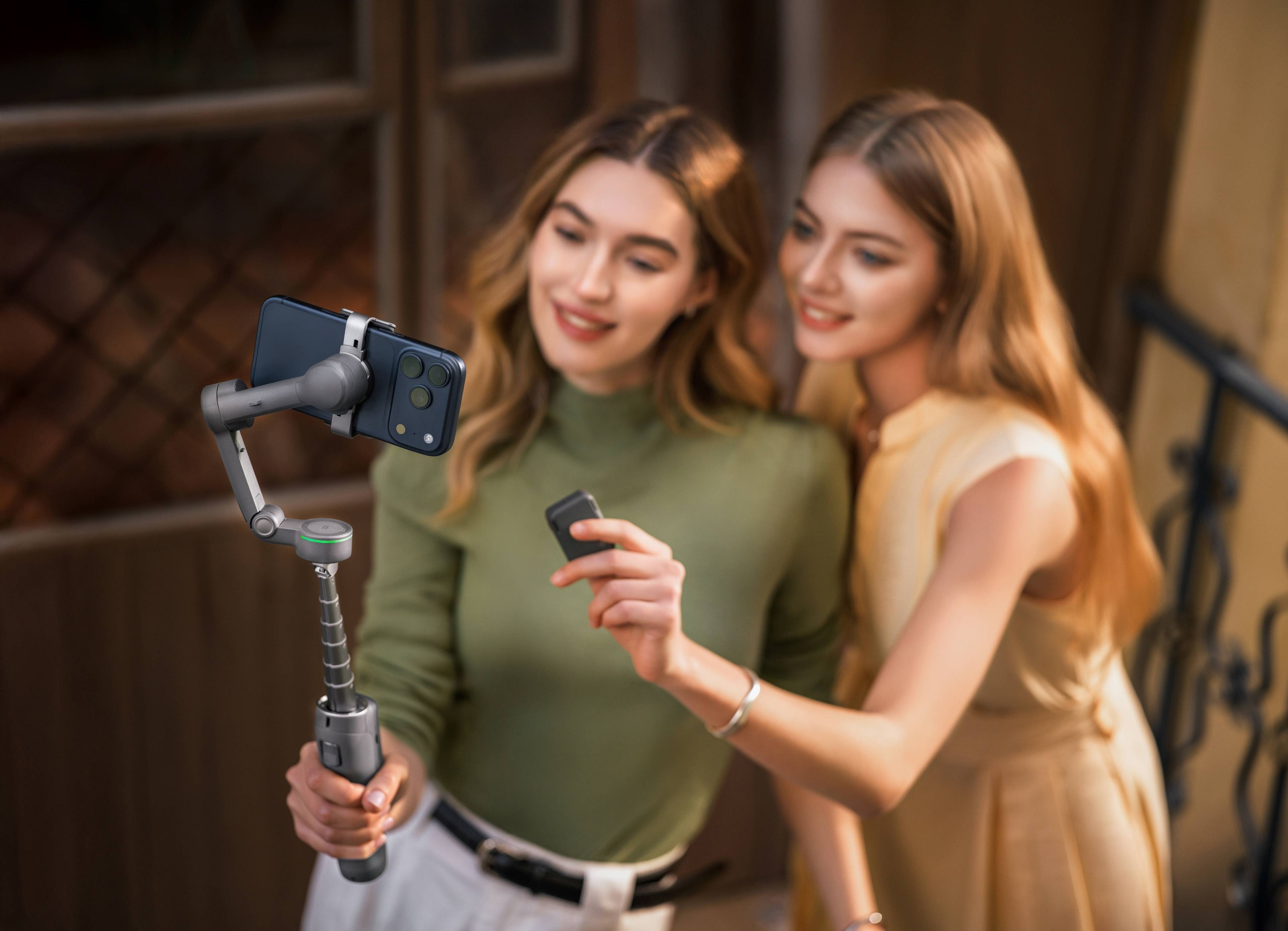 Zwei Frauen nutzen den DJI Osmo Mobile 8P Standard Combo für Selfies im Freien.