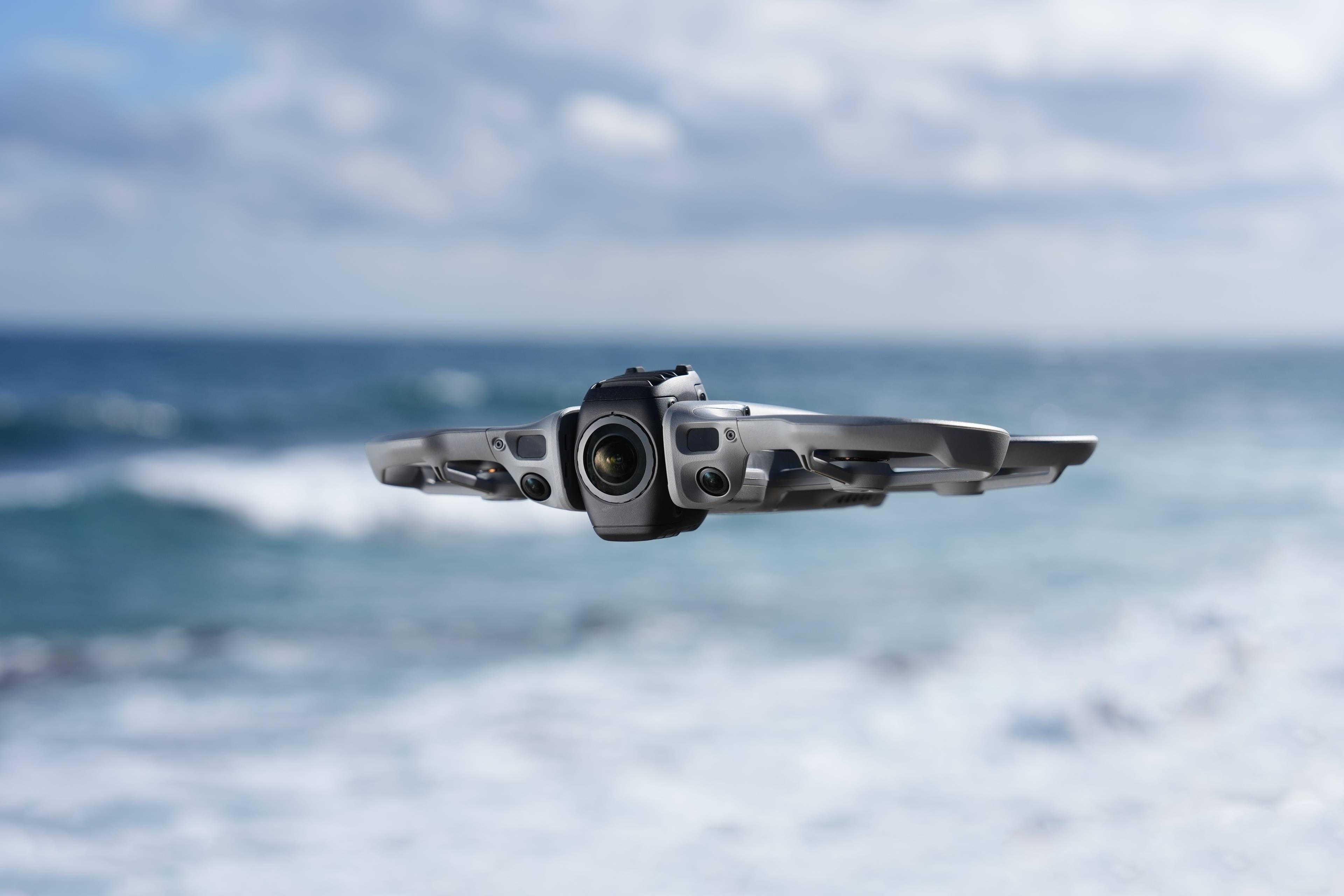 DJI Avata 360 Motion Fly More Combo: Drohne in Flugaufnahme über dem Meer mit blauen Wellen im Hintergrund.